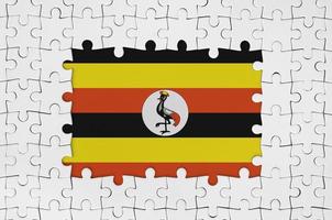Uganda flag in frame of white puzzle pieces with missing central part photo