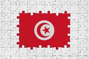 Tunisia flag in frame of white puzzle pieces with missing central part photo