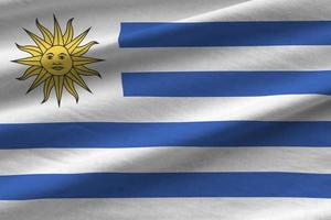 Uruguay flag with big folds waving close up under the studio light indoors. The official symbols and colors in banner photo