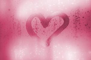 The heart is painted on the misted glass in winter Image toned in Viva Magenta, color of the 2023 year photo