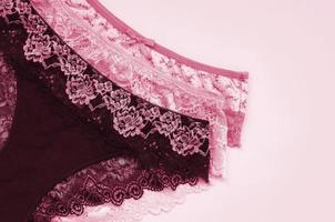 White, black and pink women underwear with lace on pink background with copy space. Advertising for shop of beautiful and comfortable women underwear Image toned in Viva Magenta, color of the year photo