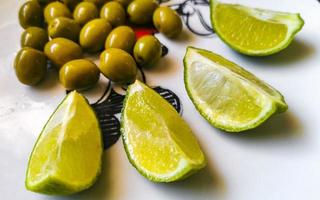 Green olives and limes on white plate in Mexico. photo