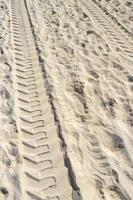 Ruts of an excavator in the beach sand in Mexico. photo