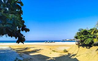 palmeras sombrillas tumbonas resort de playa zicatela puerto escondido mexico. foto