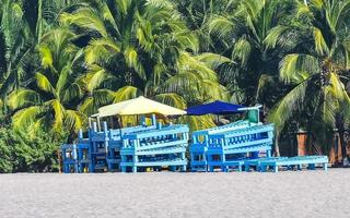 Palms parasols sun loungers beach resort Zicatela Puerto Escondido Mexico. photo