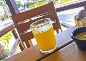 Glass of orange juice on wooden table Puerto Escondido Mexico. photo