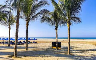 Palms parasols sun loungers beach resort Zicatela Puerto Escondido Mexico. photo