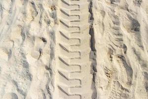 Ruts of an excavator in the beach sand in Mexico. photo