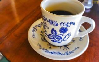 Blue white cup pot with black coffee wooden table Mexico. photo