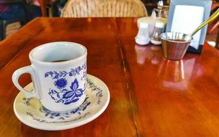 Blue white cup pot with black coffee wooden table Mexico. photo