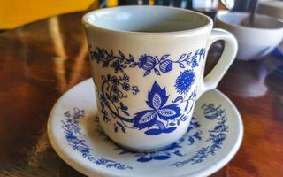 Blue white cup pot with black coffee wooden table Mexico. photo