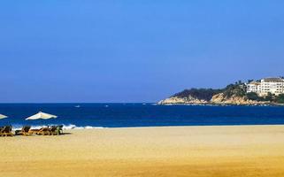 Palms parasols sun loungers beach resort Zicatela Puerto Escondido Mexico. photo