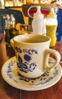 Blue white cup pot with black coffee wooden table Mexico. photo