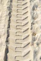 Ruts of an excavator in the beach sand in Mexico. photo