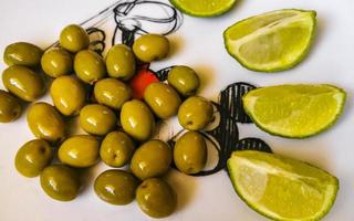 Green olives and limes on white plate in Mexico. photo