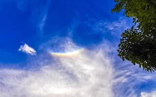 Beautiful and rare rainbow in cloudy sky blue background Mexico. photo