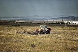 The tractor prepares the ground for sowing and cultivation. Agriculture and agronomy concept. photo