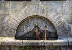 bebedero un bebedero urbano. mezclador público para agua potable. agua de la fuente de piedra. foto