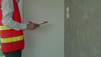 ingenieurs opnieuw controleren macht lijn systemen voor nieuw huis. inspecteur gebruik tooling opnieuw controleren macht stopcontact. contactor Vermelding resultaat van laatste inspectie voordat voorbij gaan aan naar klant. inspecteur ingenieur concept. video