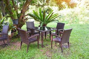 Table and chairs in the garden under the tree summer - Set of table chair outdoor nature green background photo