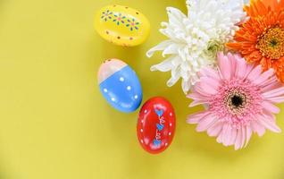 decoración de huevos de pascua con coloridas flores de primavera gerbera y crisantemo en amarillo foto