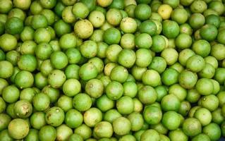 Fondo de textura de lima limón verde fresco pila de lima a la venta en el mercado foto