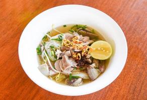 delicious noodles bowl close up of vermicelli noodles soup spicy with pork stew vegetable and lemon in bowl traditional thai and chinese style food of asia , Pork offal , Liver pork intestines photo