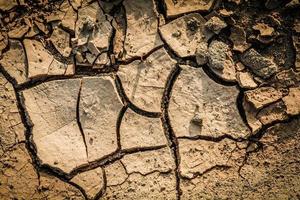 fondo de grietas en el suelo textura del suelo y temporada barro seco tierra árida foto