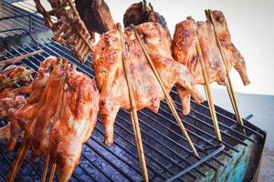 Thai style food grilled chicken with bamboo stick on the grill photo