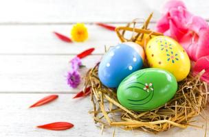 Easter eggs in nest decoration with colorful Gladiolus flowers petal on white photo