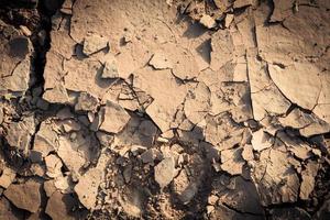 fondo de grietas en el suelo textura del suelo y temporada barro seco tierra árida foto