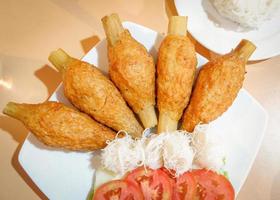 camarones fritos con caña de azúcar con fideos de arroz y tomate en un plato de comida tailandesa foto