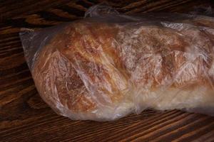 A loaf of bread wrapped in a plastic bag. photo