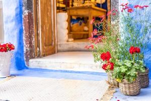 casa tradicional griega como tienda, arquitectura cíclica, santorini, grecia. flores y entrada antigua, diseño vintage, estado de ánimo relajante de verano foto