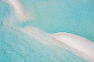 Beautiful sand bank, aerial view of sea surface. Top view of transparent turquoise ocean water surface, ripples and soft waves. Beautiful nature environment. Sea ocean water concept, sunny weather photo