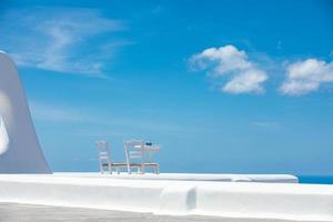 Romantic table set-up in Santorini Greece. White architecture and table for two. Love concept in romantic travel destination, summer holiday or vacation concept. photo