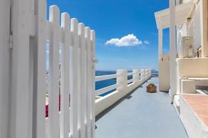puerta blanca en hotel resort de lujo en santorini, grecia. luna de miel verano egeo fondo cicládico, serenidad, tranquilidad. hermosa arquitectura blanca y cielo azul con vista al mar, vacaciones de verano foto