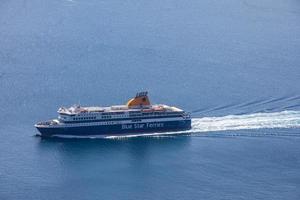 Greece, Santorini 05.08.19 - Santorini Greece, aerial caldera view ocean of ferry and passenger cruise ship boats passing true. Sea transportation in famous european travel destination photo