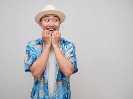 el hombre asiático usa sombrero camisa de playa se siente asombrado mirando el espacio de la copia foto