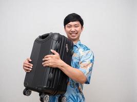 Young man beach shirt gesture carry heavy laggage travel at holiday isolated photo