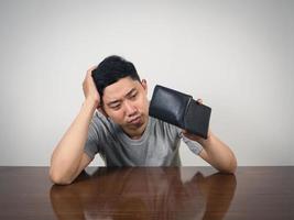 Poor man strain with no money hold wallet at table photo