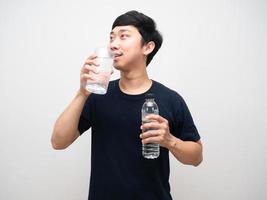 Young man black shirt drinking water and holding water bottle portrait photo