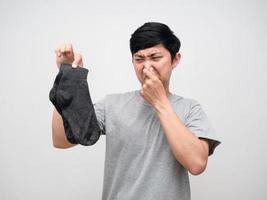 Asian man holding dirty socks close his nose feels smelly portrait photo