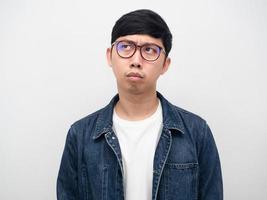 Young man glasses jeans serious thinking looking up portrait photo