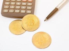 Close up gold bitcoin with pen top view,Workplace isolated light flare photo