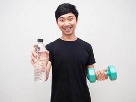Healhty man smile hold dumbbell giving water bottle at you photo