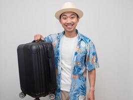 Positive traveler man smile happy and hold luggage isolated photo