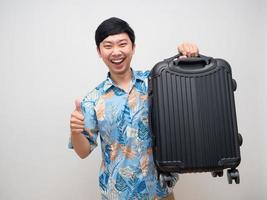 Cheerful man happy smile holding laggage and thumb up isolated photo