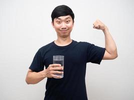 hombre positivo sonrisa amable sosteniendo un vaso de agua muestra músculo con un buen retrato saludable foto