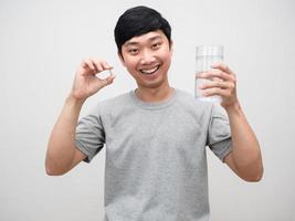 hombre positivo fresco saludable sosteniendo vitamina con un vaso de agua sonrisa feliz aislado foto